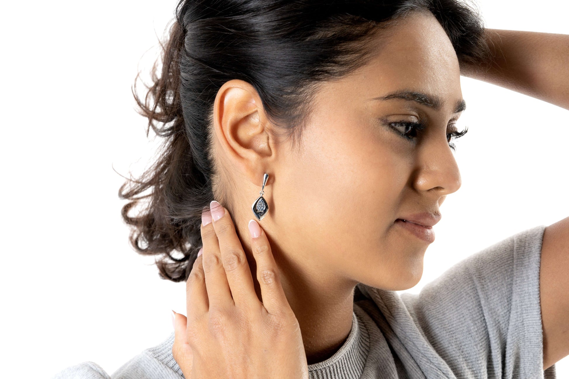 Orecchini Pavè Kallia indossati da modella, evidenziando il design moderno e le pietre zirconia blu.