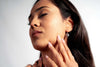 Close-up of a woman wearing Meloré silver earrings, highlighting elegance and craftsmanship.